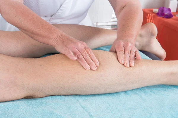 Osteópata aplicando presión con el pulgar en el músculo de la pantorrilla masculina . —  Fotos de Stock