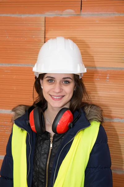 Uma trabalhadora de construção feminina com área de construção atrás — Fotografia de Stock