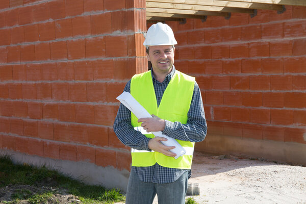 Successful male architect at a building site with arms crossed