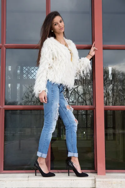 Brunette jonge vrouw dragen jeans, witte top staande op windows — Stockfoto