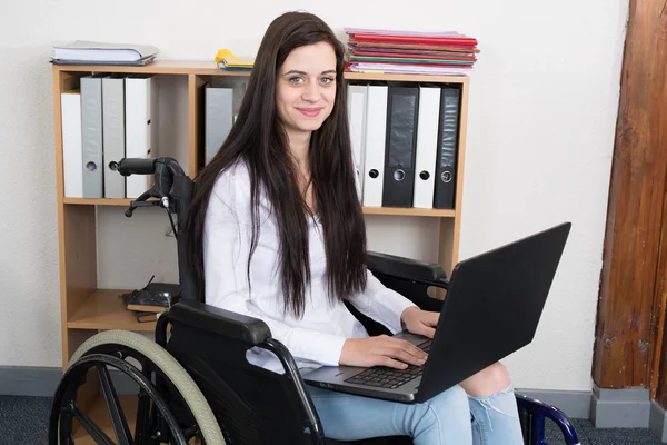 Confident happy businesswoman in wheelchair working at office desk — Stock Photo, Image