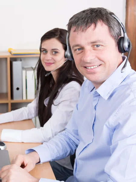 Mosolygó manager segít a call center ügynök-val egy fejhallgató — Stock Fotó