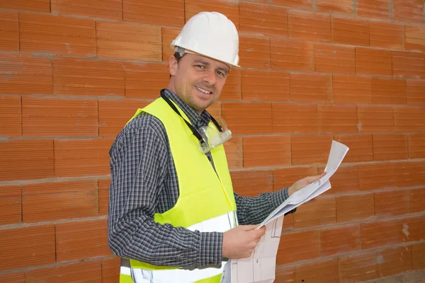Χαμογελαστός διαχειριστής κατασκευή στέκεται στο εργοτάξιο — Φωτογραφία Αρχείου