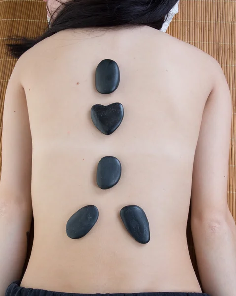 Closeup on young woman receiving hot stone massage — Stock Photo, Image