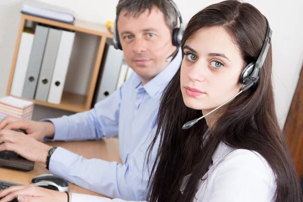 Callcenter operatörer - ler arbetstagare på kontoret med hörlurar — Stockfoto