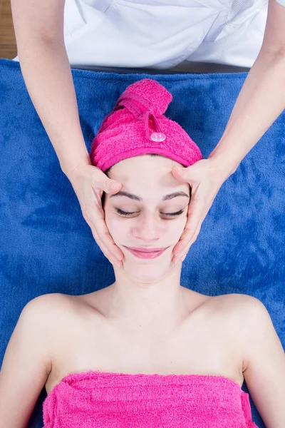 Gesichtsmassage. Nahaufnahme einer jungen Frau, die sich im Wellnessbereich behandeln lässt. — Stockfoto