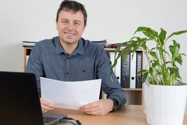 Empresario sentado en el escritorio leyendo documentos en serio — Foto de Stock