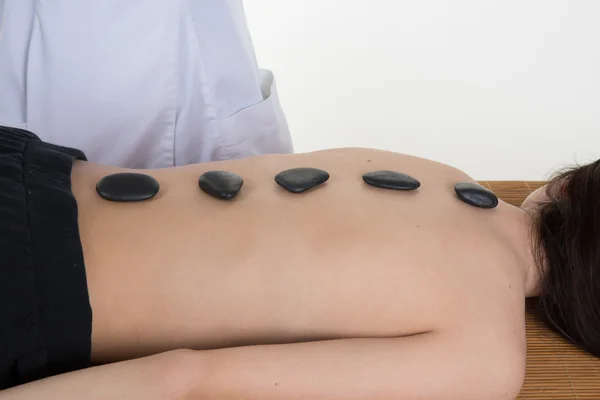 Picture of woman in spa salon with hot stones — Stock Photo, Image