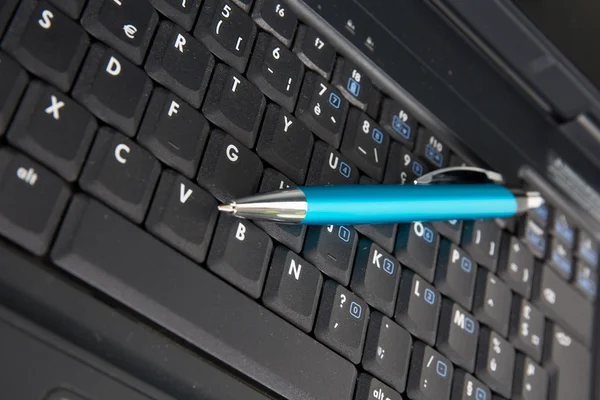 Close up de laptop com caneta azul sobre ele, negócio — Fotografia de Stock