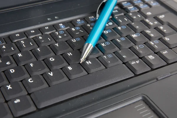 Komputer przenośny z niebieski długopis na nim, biznes — Zdjęcie stockowe