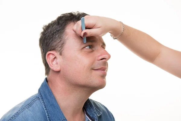 Close-up van man met een pincet wenkbrauwen plukken — Stockfoto