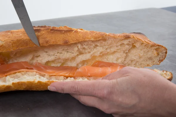 Baguette con salmón ahumado, manos de mujer —  Fotos de Stock