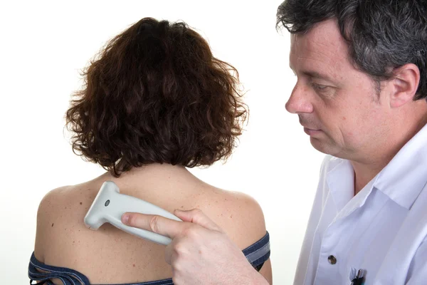 Medico fiducioso che utilizza una macchina a ultrasuoni sulla schiena della donna — Foto Stock