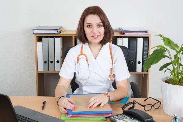 Young female doctor sitting at desk in hospital — Stock Photo, Image