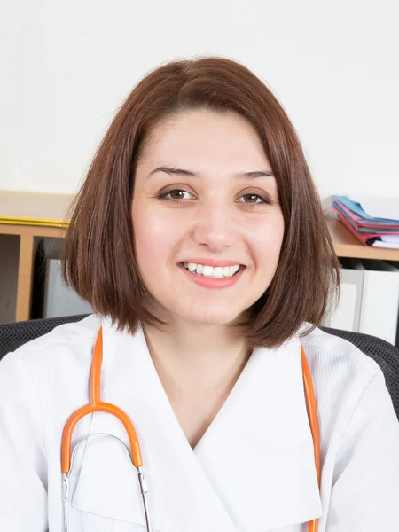 Close up of female doctor sitting at desk in hospital — Stock Photo, Image