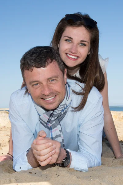 Sorrindo jovem casal piggyback na bela praia de verão — Fotografia de Stock