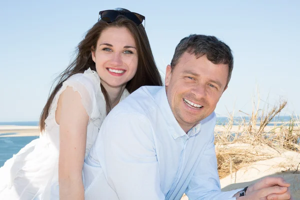 Smiling young couple piggyback at beautiful summer beach — Stock Photo, Image