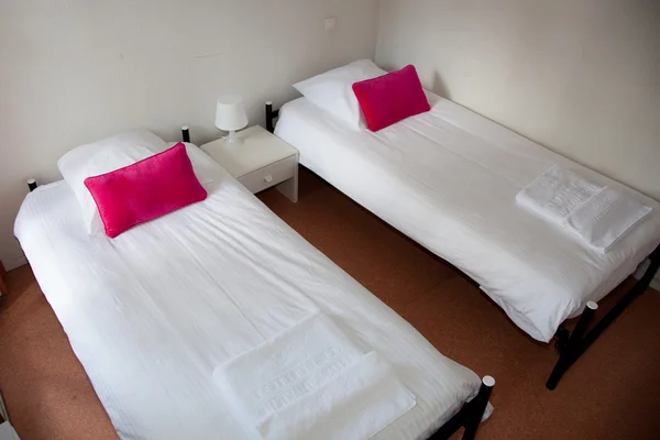 Duas camas com mesa de cabeceira e lâmpada branca . — Fotografia de Stock
