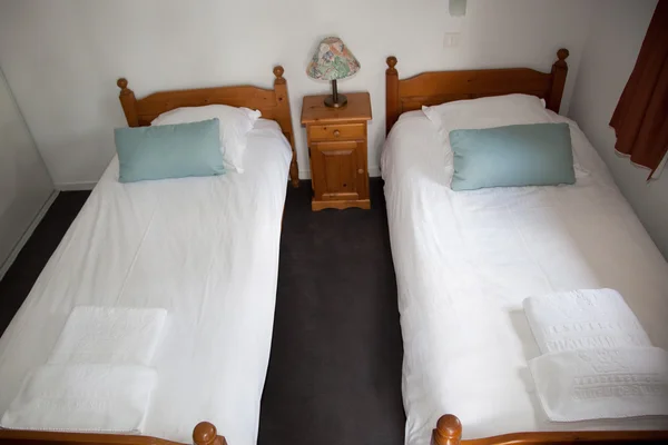 Dormitorio de dos camas con mesita de noche y lámpara . —  Fotos de Stock