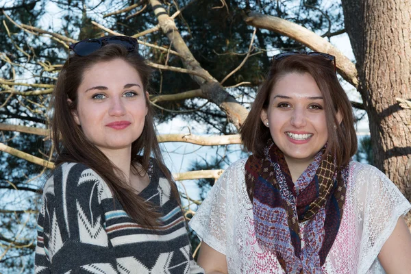 Zwei Mädchen am Strand lächeln mit Bäumen — Stockfoto