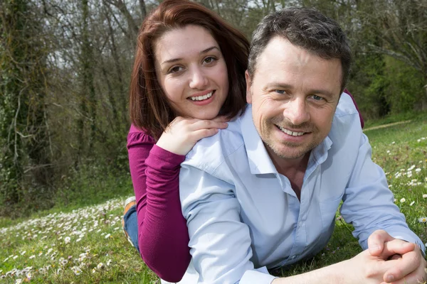 Lächelndes Paar entspannt auf grünem Gras. — Stockfoto