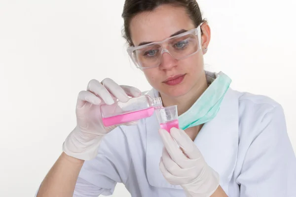 Mujer poniendo una muestra en un tubo de ensayo en un laboratorio químico —  Fotos de Stock