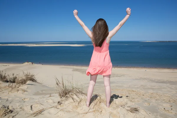 Lycklig kvinna njuta avkopplande brisen och frihet vid havet. Joyful asiatisk tjej att höja armarna mot himlen. — Stockfoto