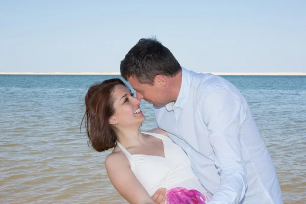 Sorridente e bella coppia sulla spiaggia — Foto Stock