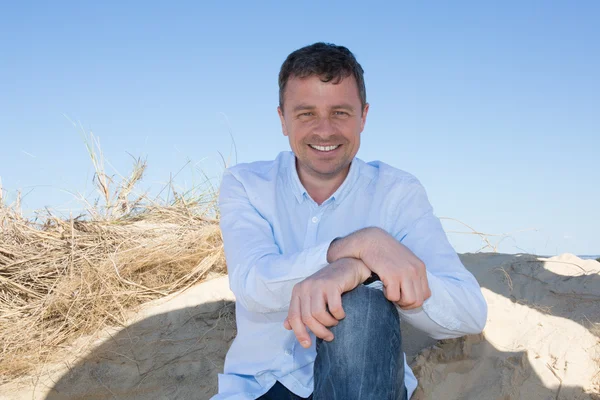 Homme heureux portant des vêtements bleus au bord de la mer — Photo