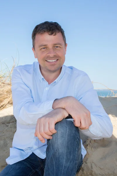 Good looking man wearing blue clothes by the sea — Stock Photo, Image