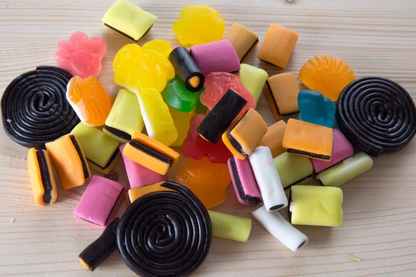 Ahşap masa arka plan üzerinde renkli şekerler — Stok fotoğraf