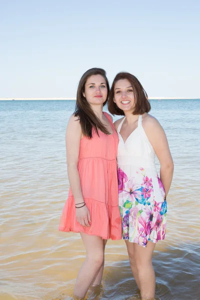 Zwei junge Mädchen verspielt im Wasser am Strand — Stockfoto