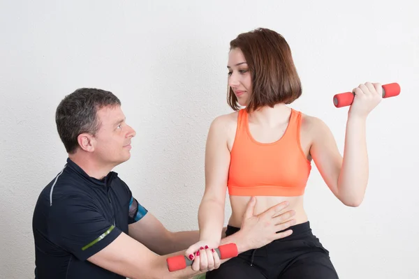 Žena, která dělá fitness cvičení s pomocí trenéra sportovní Gym — Stock fotografie