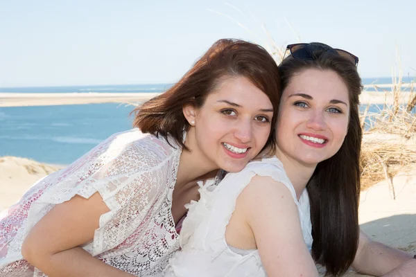 Twee aantrekkelijke jonge meisje vrienden staan samen en poseren op camera. — Stockfoto