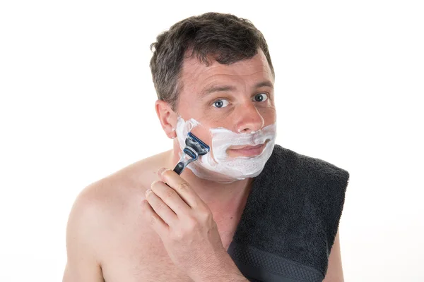 Smiling male shaving with a razor looking at you — Stock Photo, Image