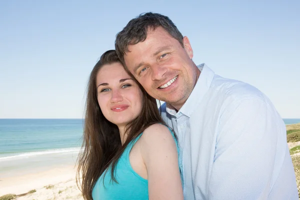 Romantiska leende glada par på stranden — Stockfoto