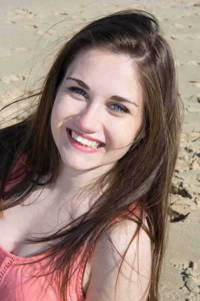 Schöne blaue Augen Mädchen sitzt am Sand im Urlaub — Stockfoto