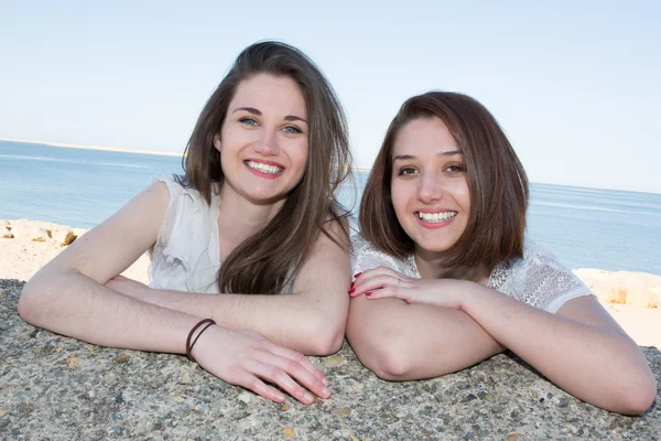 Glückliche junge Frauen liegen vor dem Meer — Stockfoto