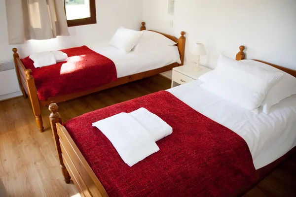 Dormitorio en una casa nueva con dos camas individuales rojas — Foto de Stock