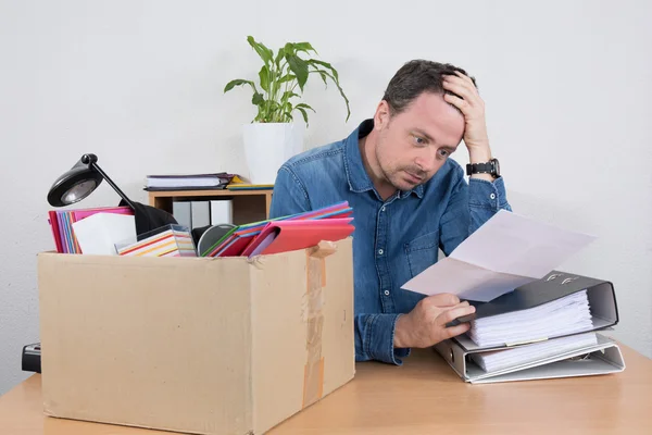 Desperate man reading a dismiss notification, preparing his box — Stock Photo, Image