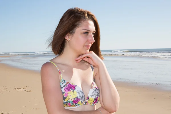 Mujer joven pensativa mirando hacia otro lado con el mar en el fondo — Foto de Stock