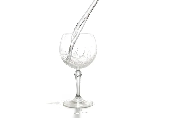 Flusso d'acqua in un bicchiere di vino isolato su sfondo bianco — Foto Stock
