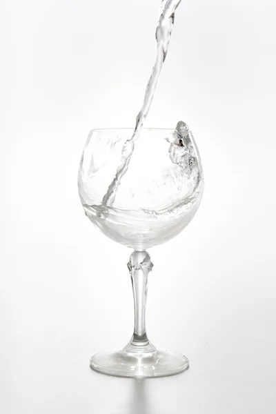 Flusso d'acqua in un bicchiere di vino isolato su bianco — Foto Stock