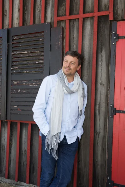 Thoughtful man smiling outside with a scarf