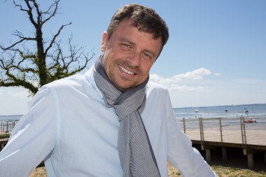 Plaj kameraya gülümseyen güzel adam