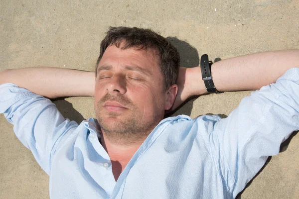 Man at the beach relaxing on the sand — Stock Photo, Image