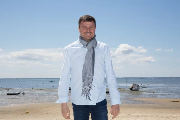 Happy gorgeous handsome man with blue shirt posing at the Sea — Stock Photo, Image