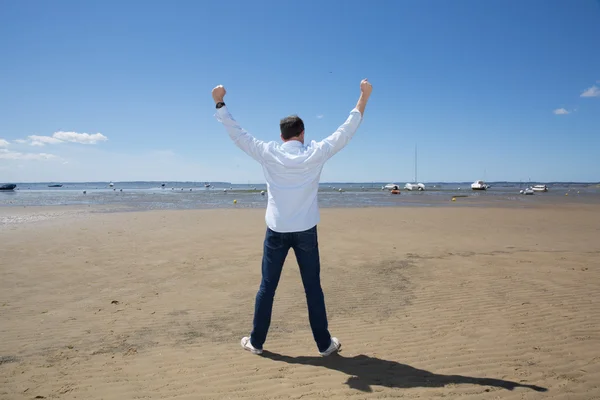 Vrijheid voor de mens op het strand met een blauwe shirt — Stockfoto