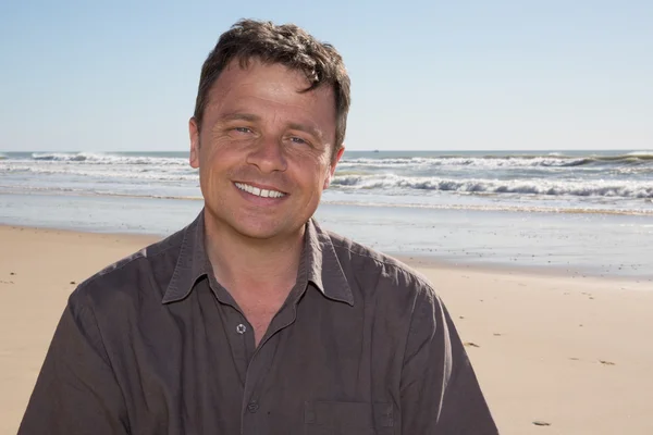 Sorridente uomo attraente e felice sulla spiaggia — Foto Stock