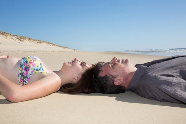 Niedliches Paar verbindet Köpfe auf Sand am Strand. — Stockfoto